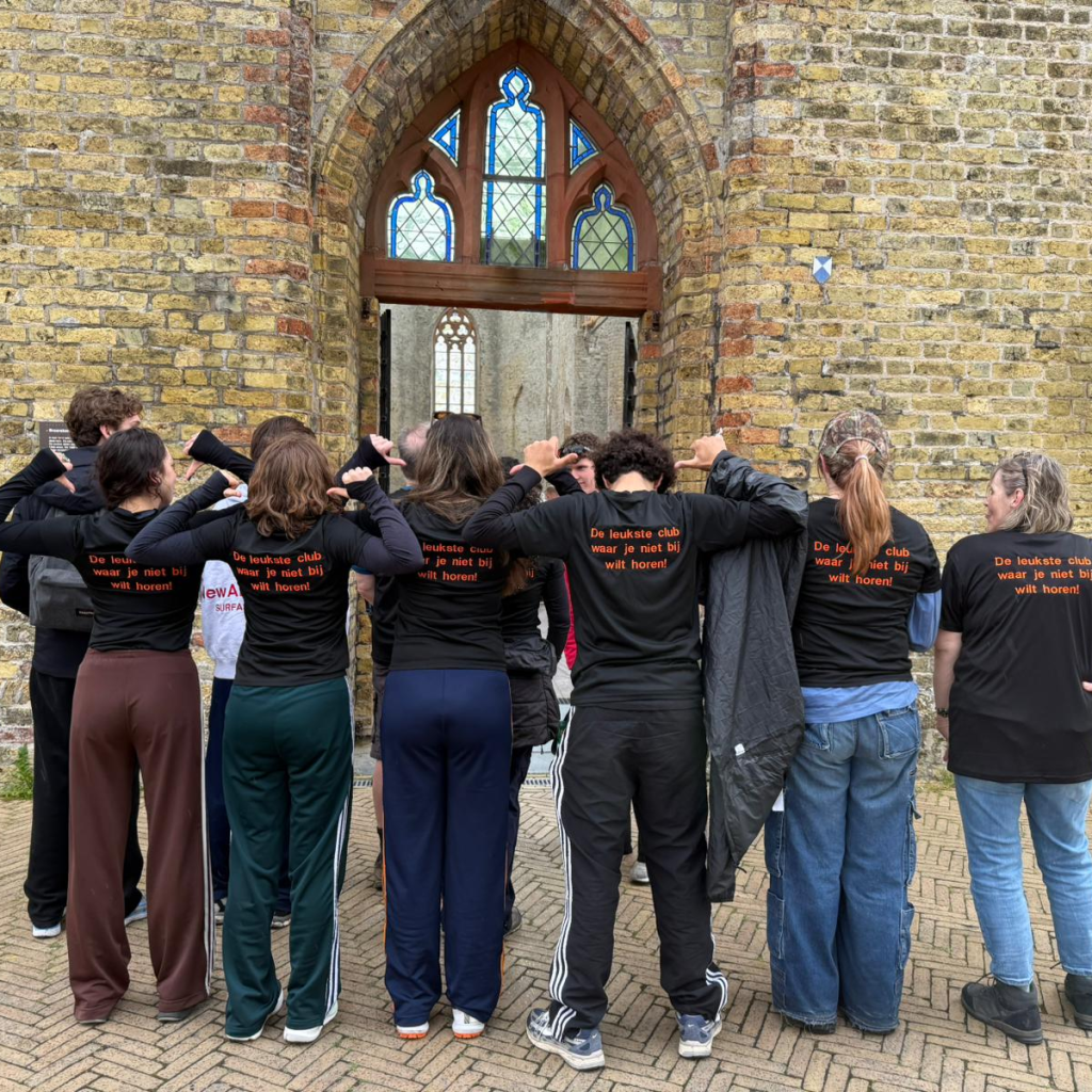 groep mensen met hun rug naar de camera met op hun shirt de tekst 'de leukste club waar je niet bij wilt horen'